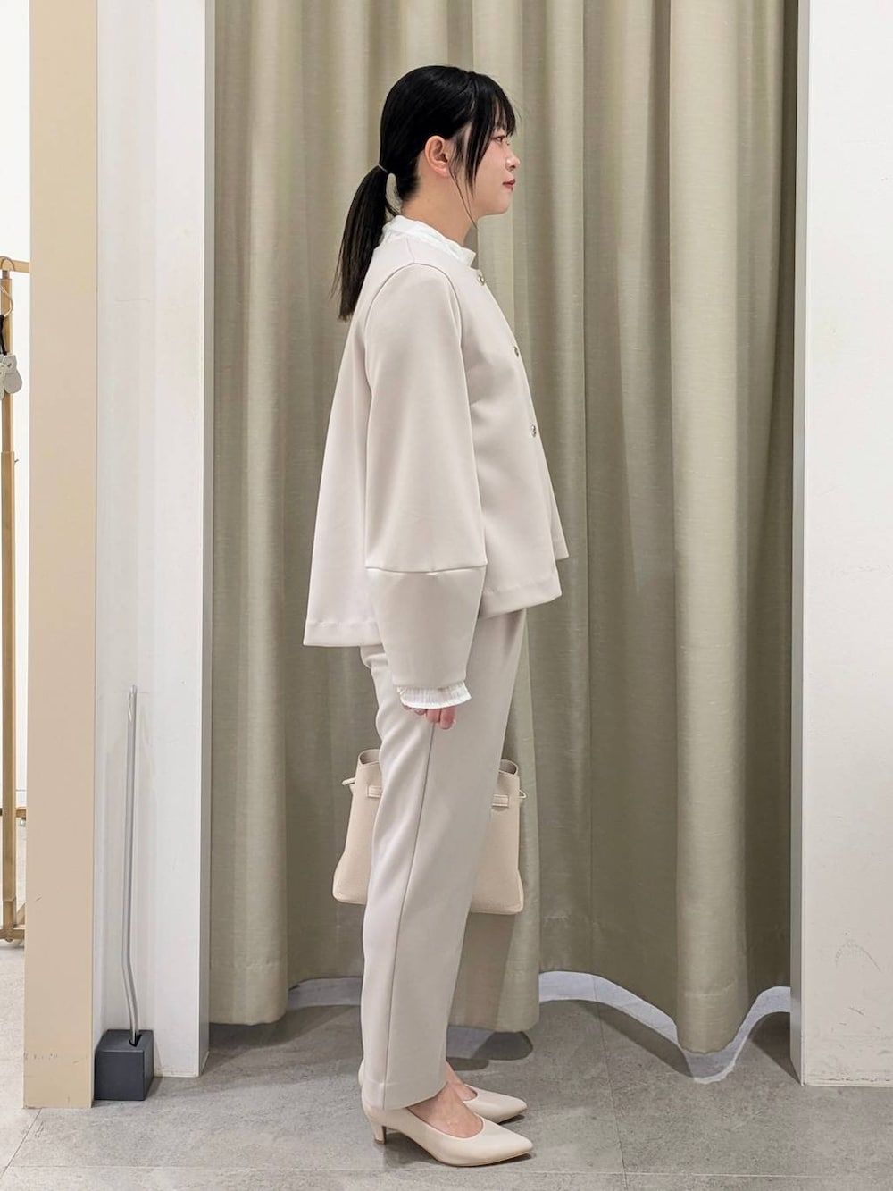 ホワイト系のパンプス、ホワイト系のシャツ/ブラウス、ベージュ系のノーカラージャケットを着用したレディースの冬コーディネートの5枚目の写真