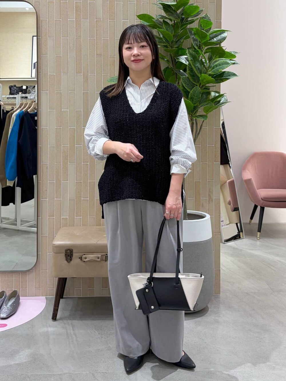 ブラック系のパンプス、ブラック系のトートバッグ、ホワイト系のシャツ/ブラウスを着用したレディースの春コーディネートの2枚目の写真