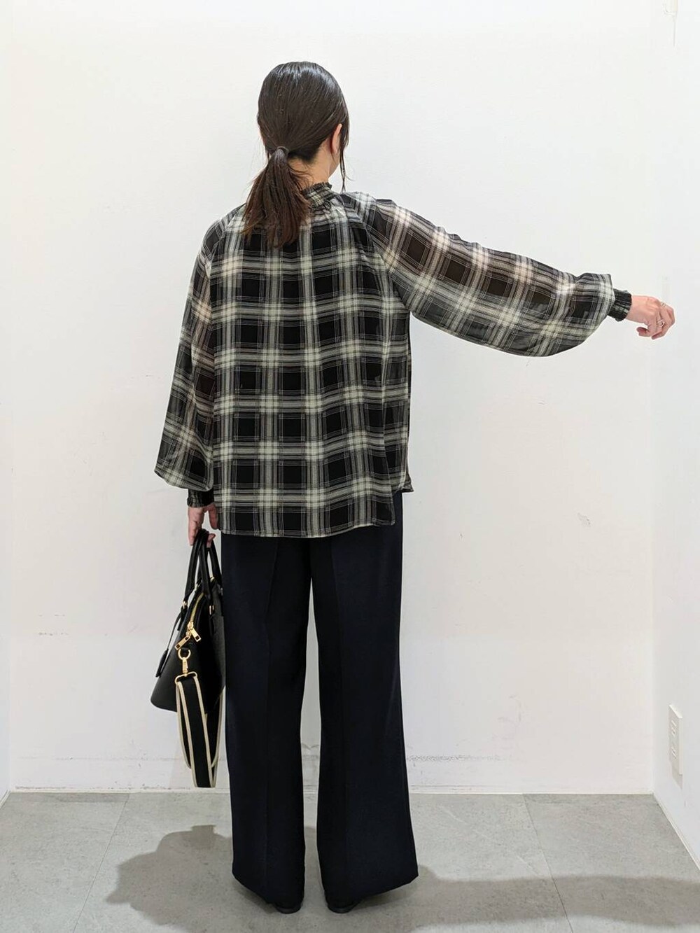 ブラック系のパンプス、ブラック系のハンドバッグ、ブルー系のその他パンツを着用したレディースの秋コーディネートの4枚目の写真