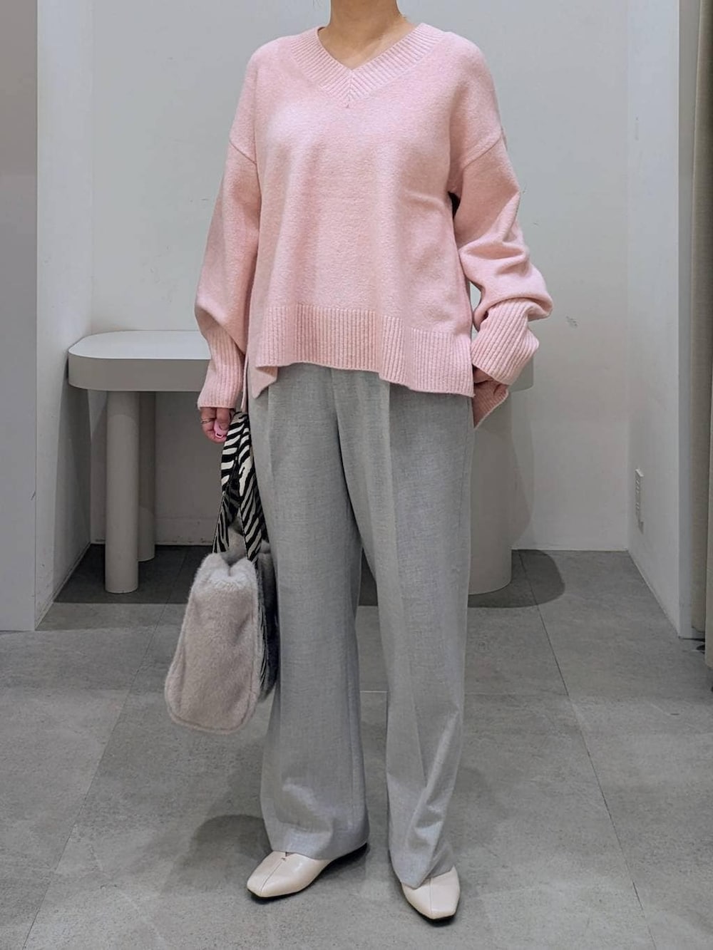 ホワイト系のパンプス、グレー系のその他パンツ、グレー系のトートバッグを着用したレディースの冬コーディネートの6枚目の写真