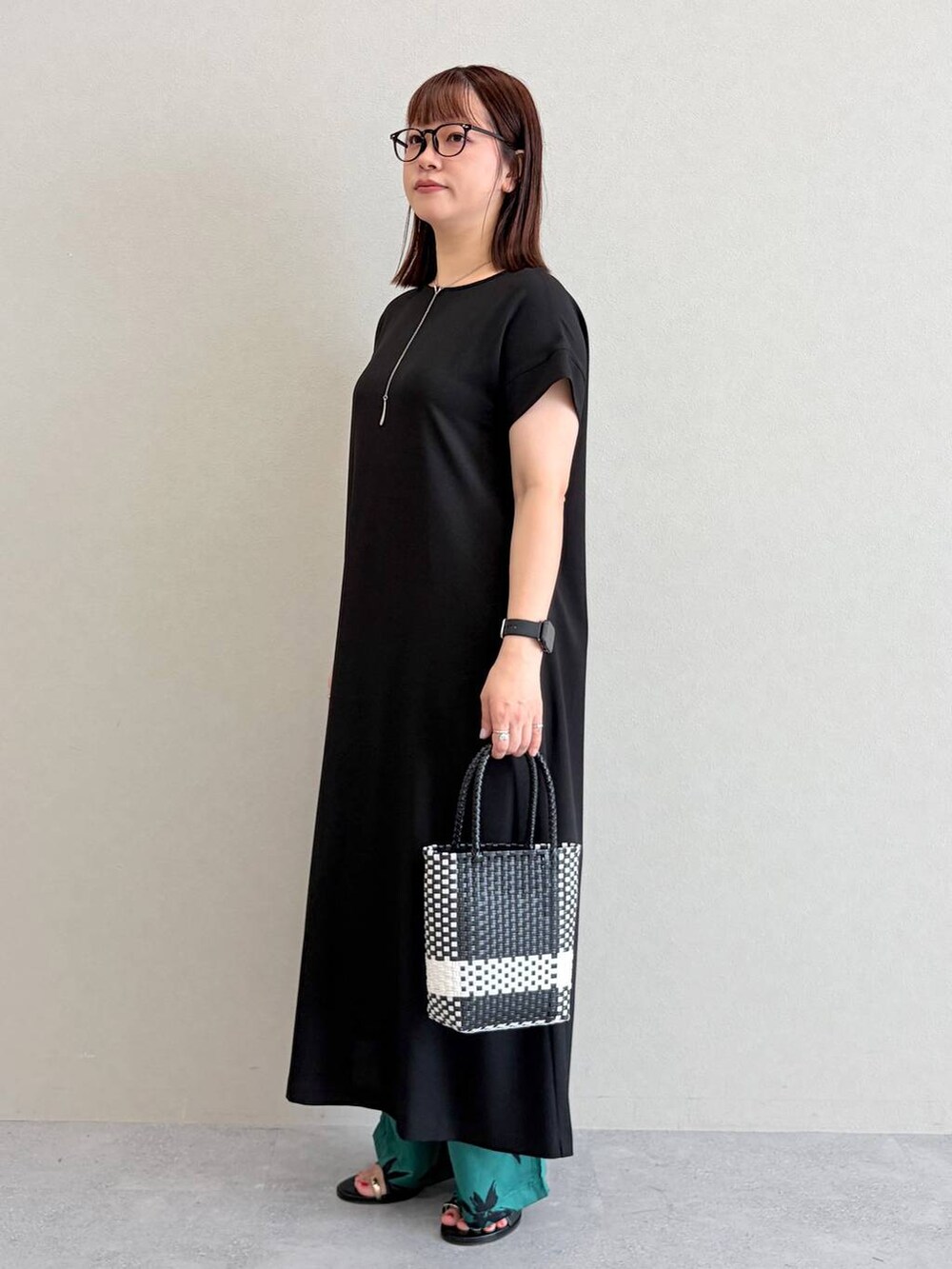 グリーン系のその他パンツ、ブラック系のかごバッグを着用したレディースの夏コーディネートの3枚目の写真