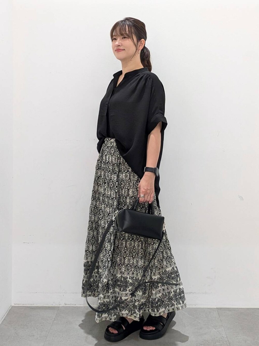 ブラック系のスカート、ブラック系のサンダル、ブラック系のTシャツ/カットソーを着用したレディースの夏コーディネートの4枚目の写真