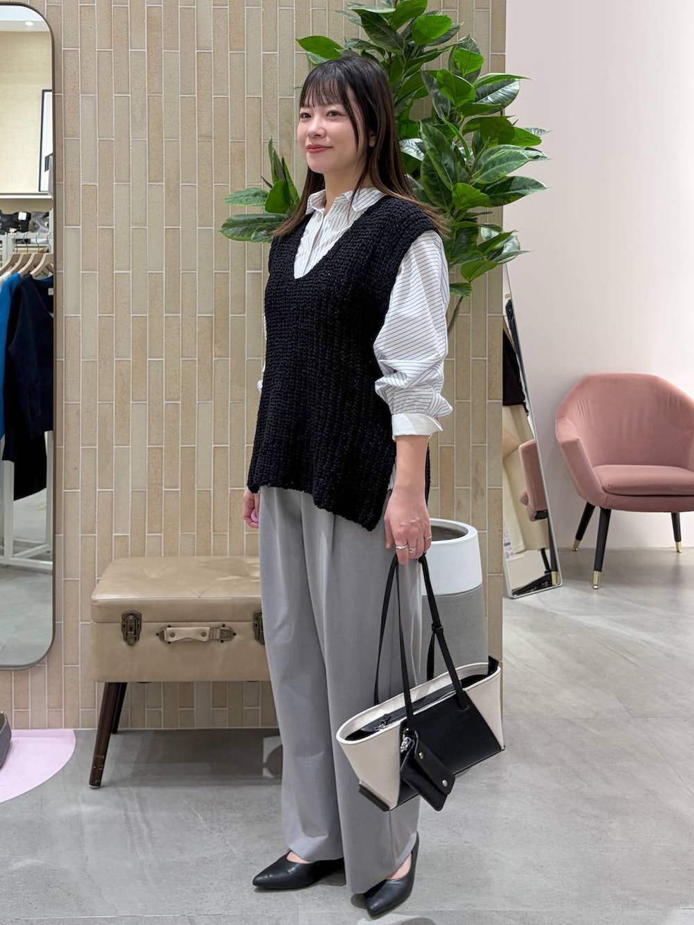 ブラック系のパンプス、ブラック系のトートバッグ、ホワイト系のシャツ/ブラウスを着用したレディースの春コーディネートの3枚目の写真