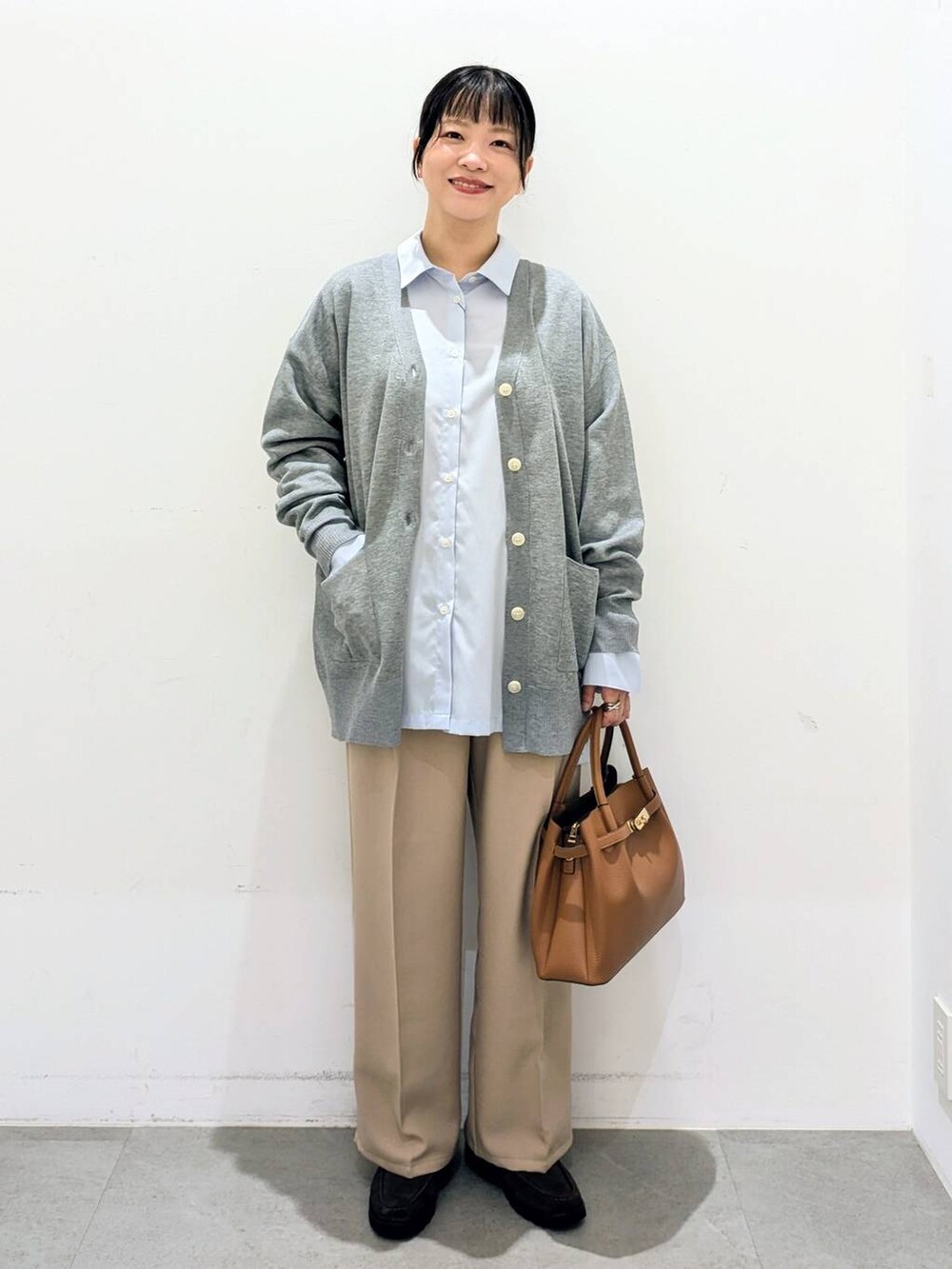 ブラウン系のハンドバッグ、ブルー系のシャツ/ブラウス、ベージュ系のその他パンツを着用したレディースの秋コーディネートの2枚目の写真