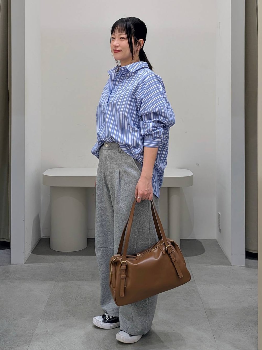 グレー系のスウェットパンツ、イエロー系のボストンバッグ、ブルー系のシャツ/ブラウスを着用したレディースの冬コーディネートの3枚目の写真