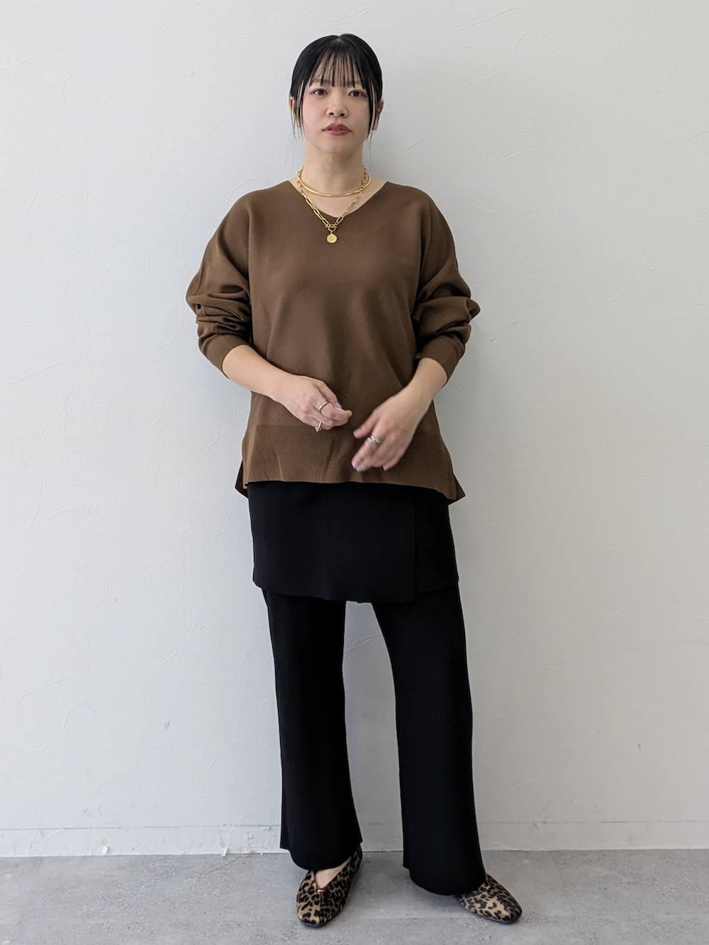 ブラウン系のパンプス、ブラック系のその他パンツ、ブラック系のスカートを着用したレディースの春コーディネートの2枚目の写真