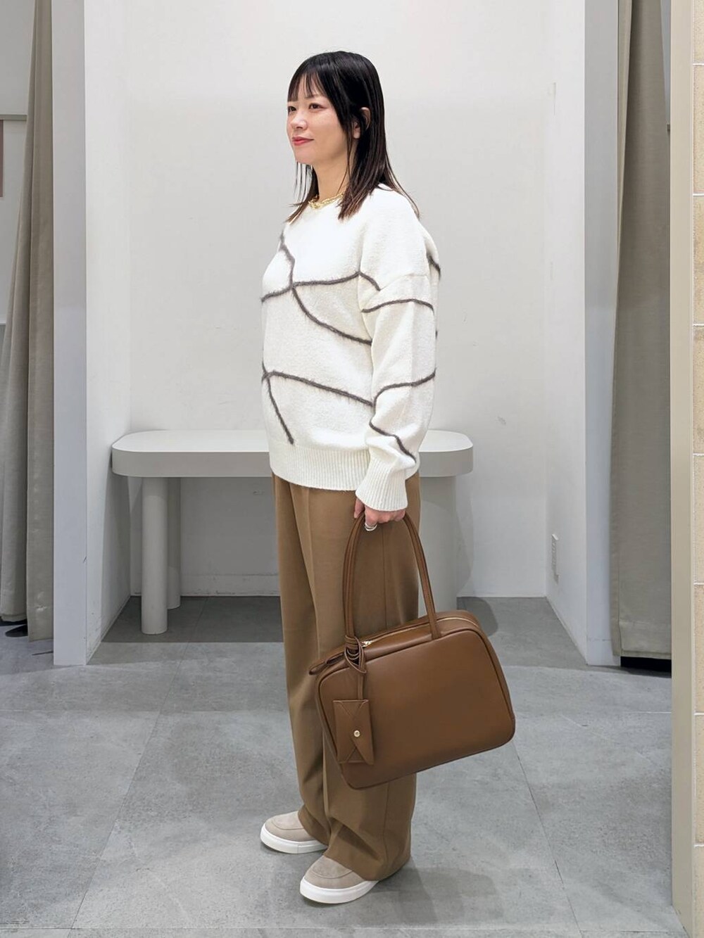 イエロー系のその他パンツ、イエロー系のボストンバッグ、ベージュ系のローファーを着用したレディースの冬コーディネートの3枚目の写真