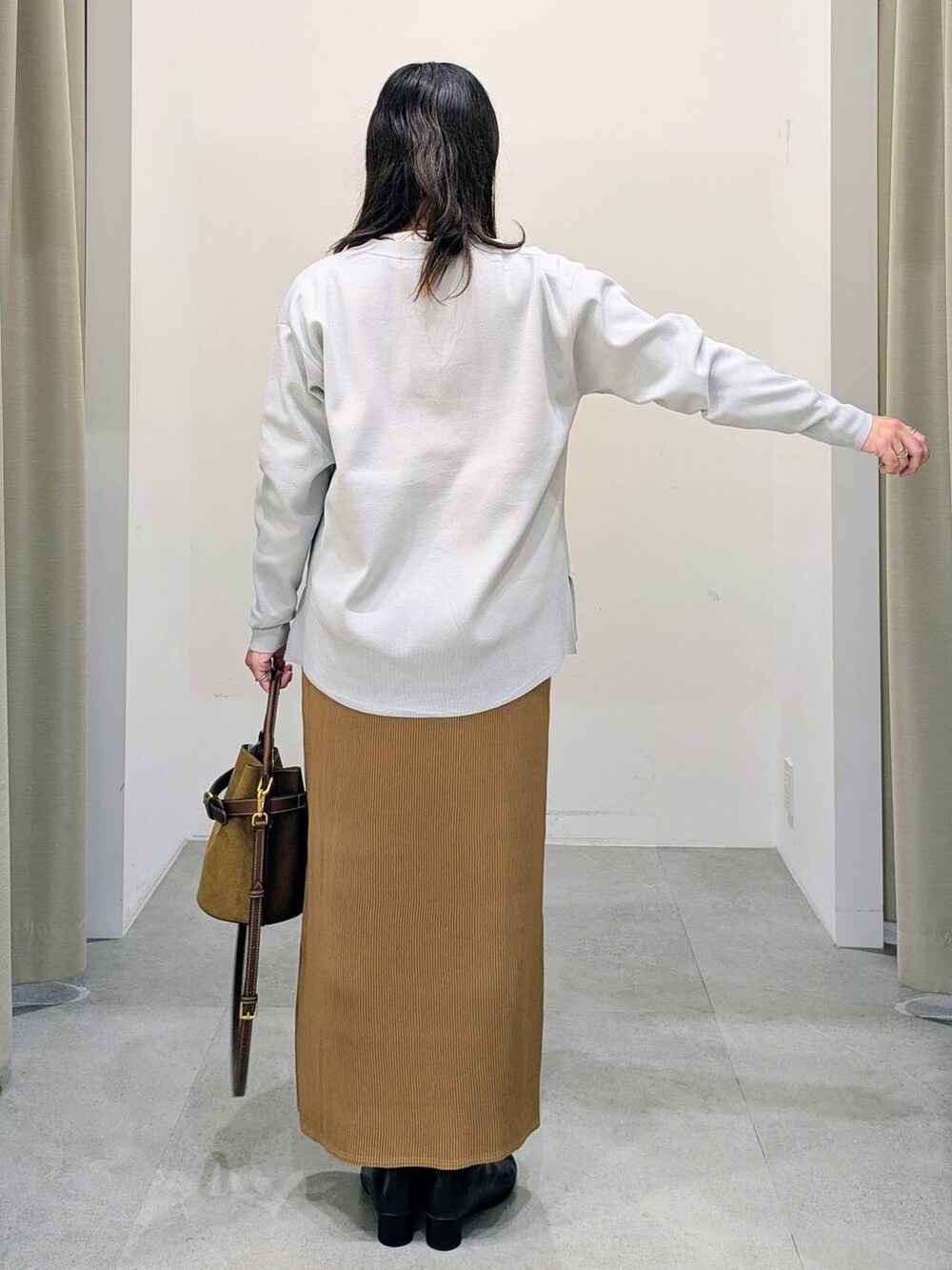 グレー系のカーディガン/ボレロ、ホワイト系のTシャツ/カットソー、ブラック系のブーツを着用したレディースの秋コーディネートの4枚目の写真