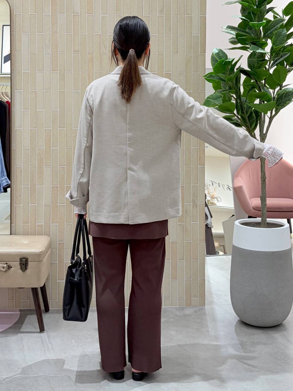 ブラック系のハンドバッグ、ブラック系のパンプス、ブラウン系のその他パンツを着用したレディースの春コーディネートの4枚目の写真