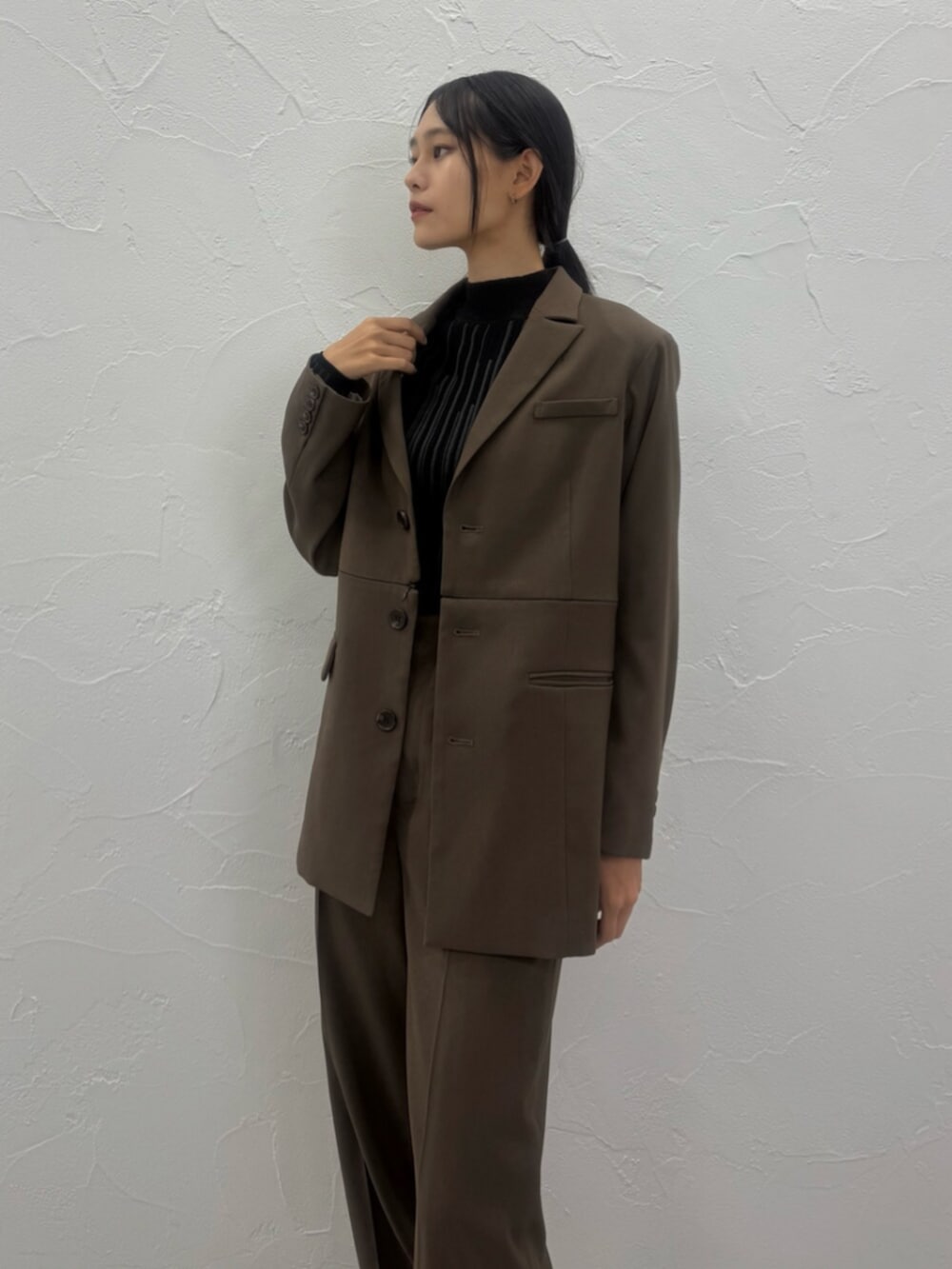 ブラウン系のブーツ、ブラウン系のテーラードジャケット、ブラウン系のスラックスを着用したレディースの夏コーディネートの3枚目の写真