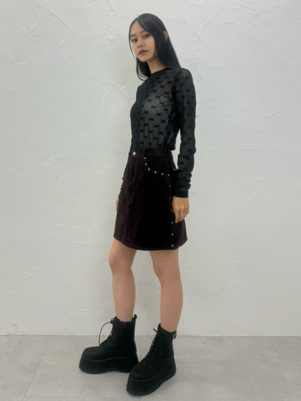 レッド系のスカート、ブラック系のTシャツ/カットソー、ブラック系のブーツを着用したレディースの夏コーディネートの3枚目の写真