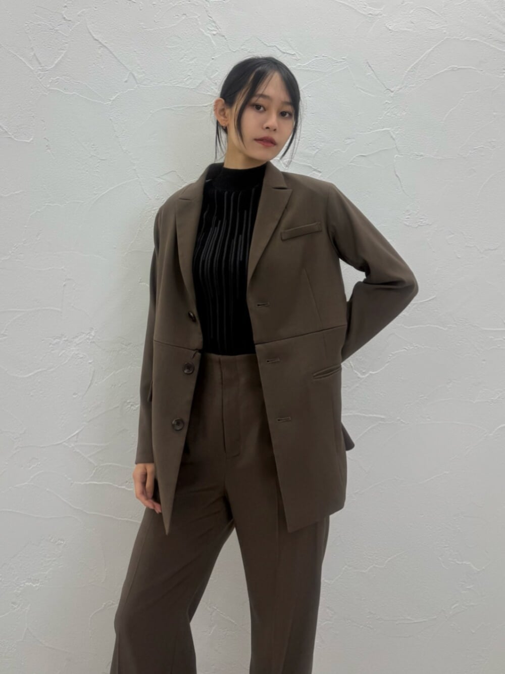 ブラウン系のブーツ、ブラウン系のテーラードジャケット、ブラウン系のスラックスを着用したレディースの夏コーディネートの2枚目の写真