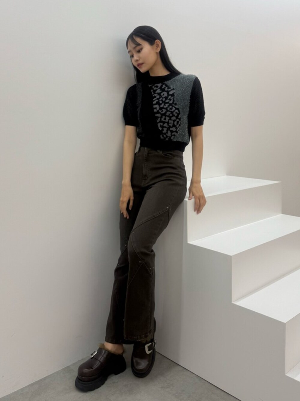 ブラウン系のデニムパンツ、ブラック系のニット/セーター、ブラウン系のサンダルを着用したレディースの夏コーディネートの4枚目の写真