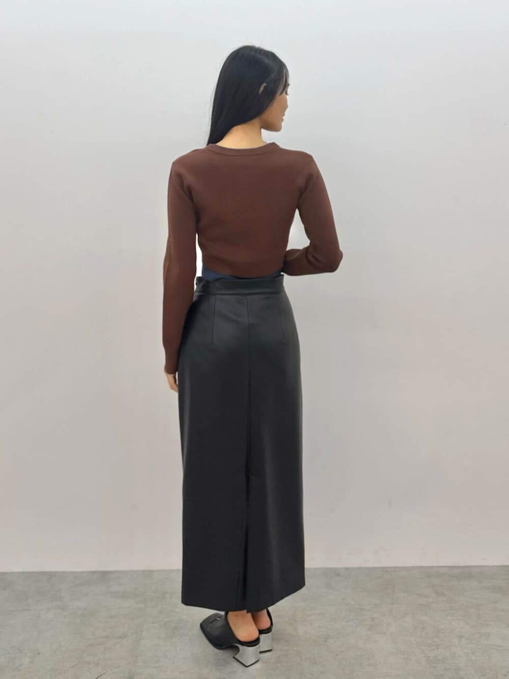ブラック系のパンプス、ブラウン系のカーディガン/ボレロ、ブラック系のスカートを着用したレディースの春コーディネートの4枚目の写真