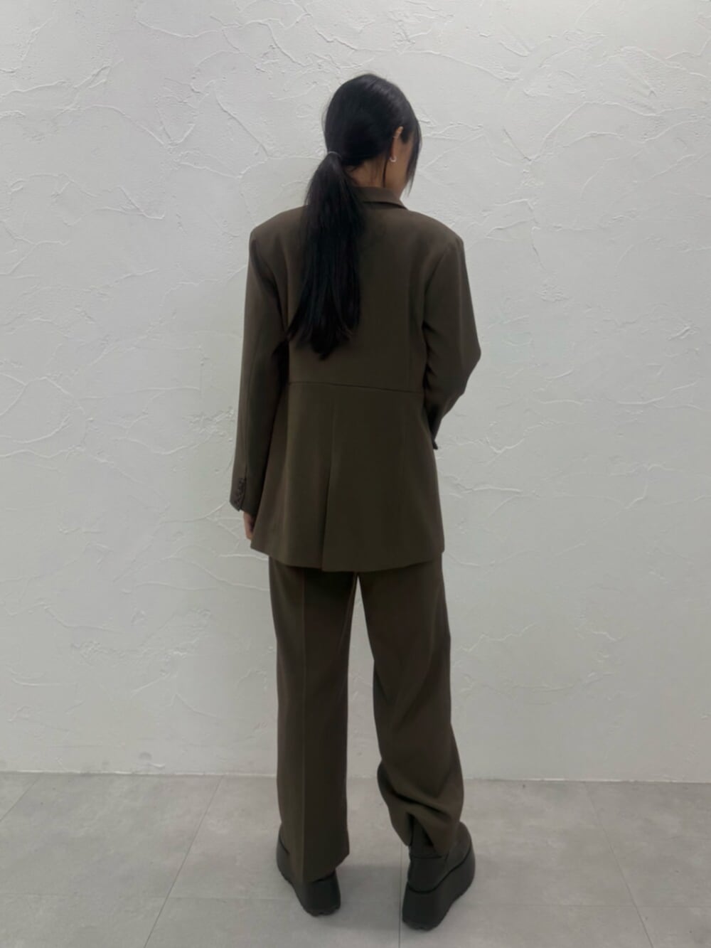 ブラウン系のブーツ、ブラウン系のテーラードジャケット、ブラウン系のスラックスを着用したレディースの夏コーディネートの6枚目の写真