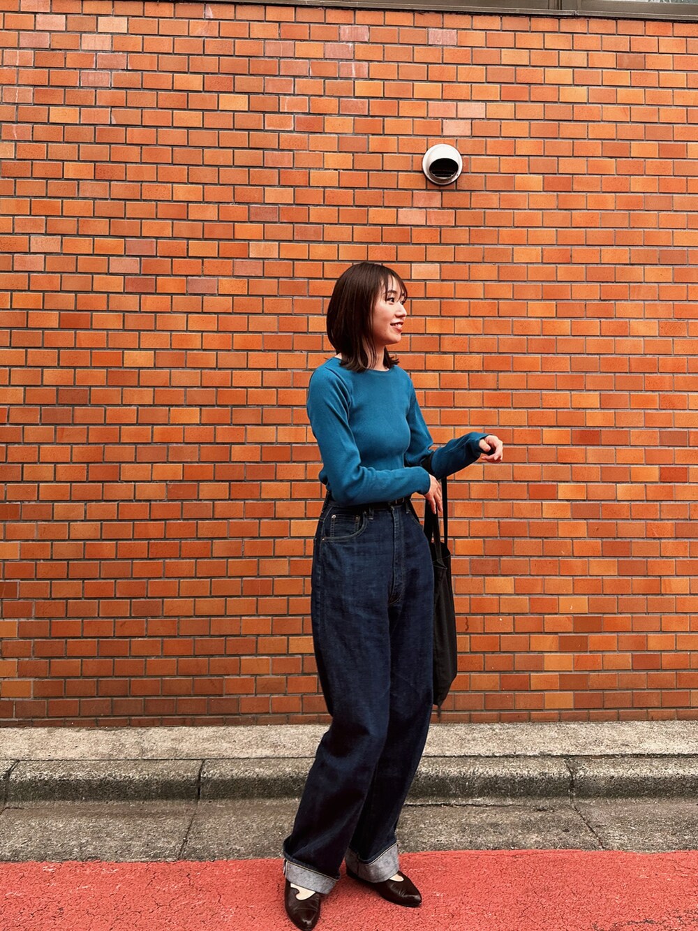 ブルー系のTシャツ/カットソーを着用したレディースの秋コーディネートの2枚目の写真