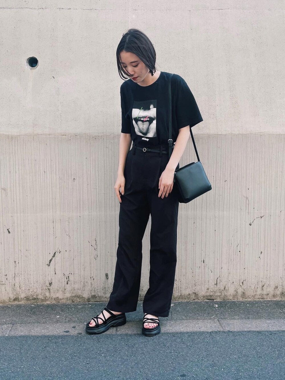 ブラック系のTシャツ/カットソー、ブラック系のスラックス、ブラック系のサンダルを着用したレディースの夏コーディネートの2枚目の写真