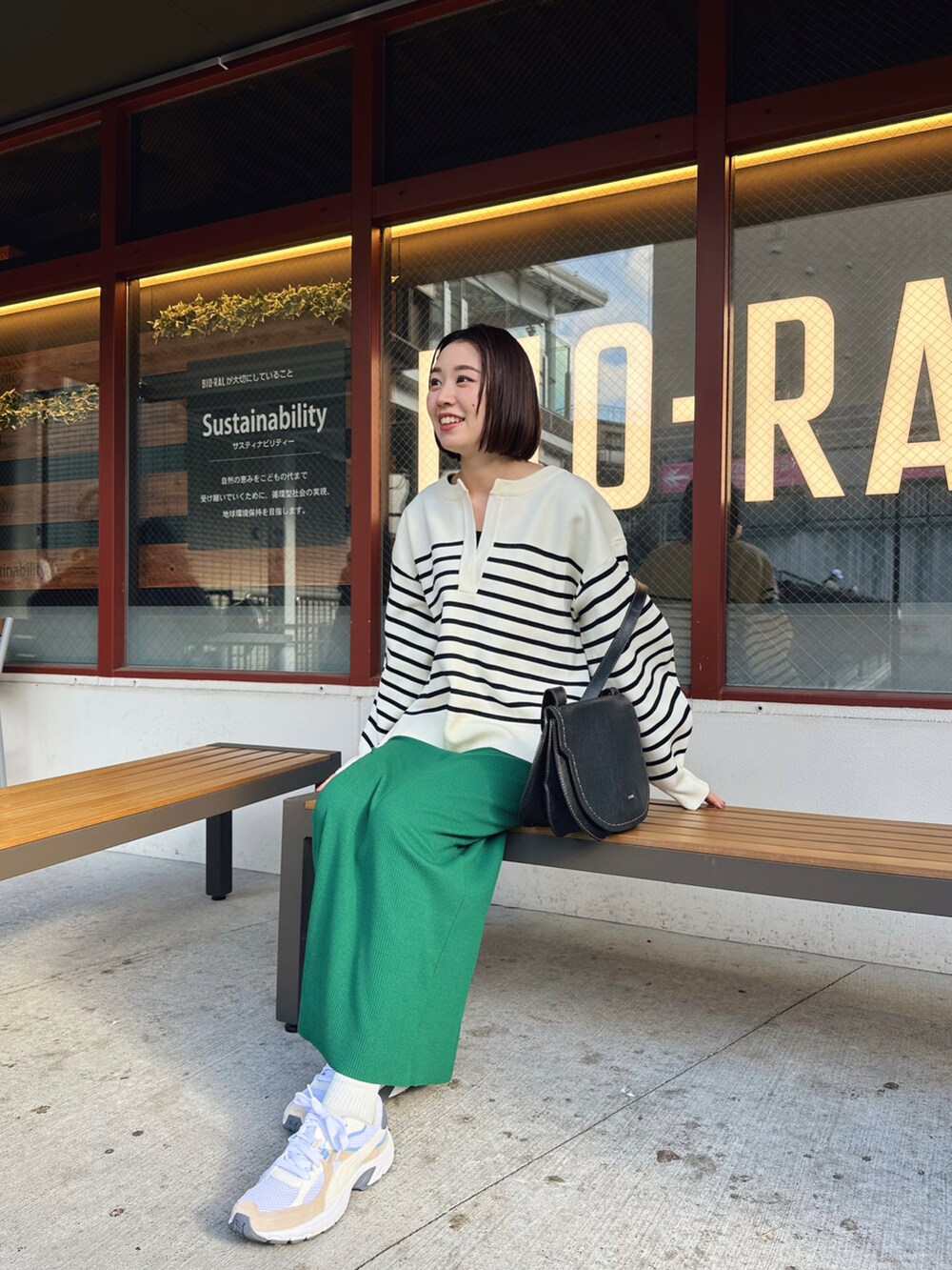 ホワイト系のその他トップス、グリーン系のスカート、ホワイト系のスニーカーを着用したレディースの春コーディネートの2枚目の写真