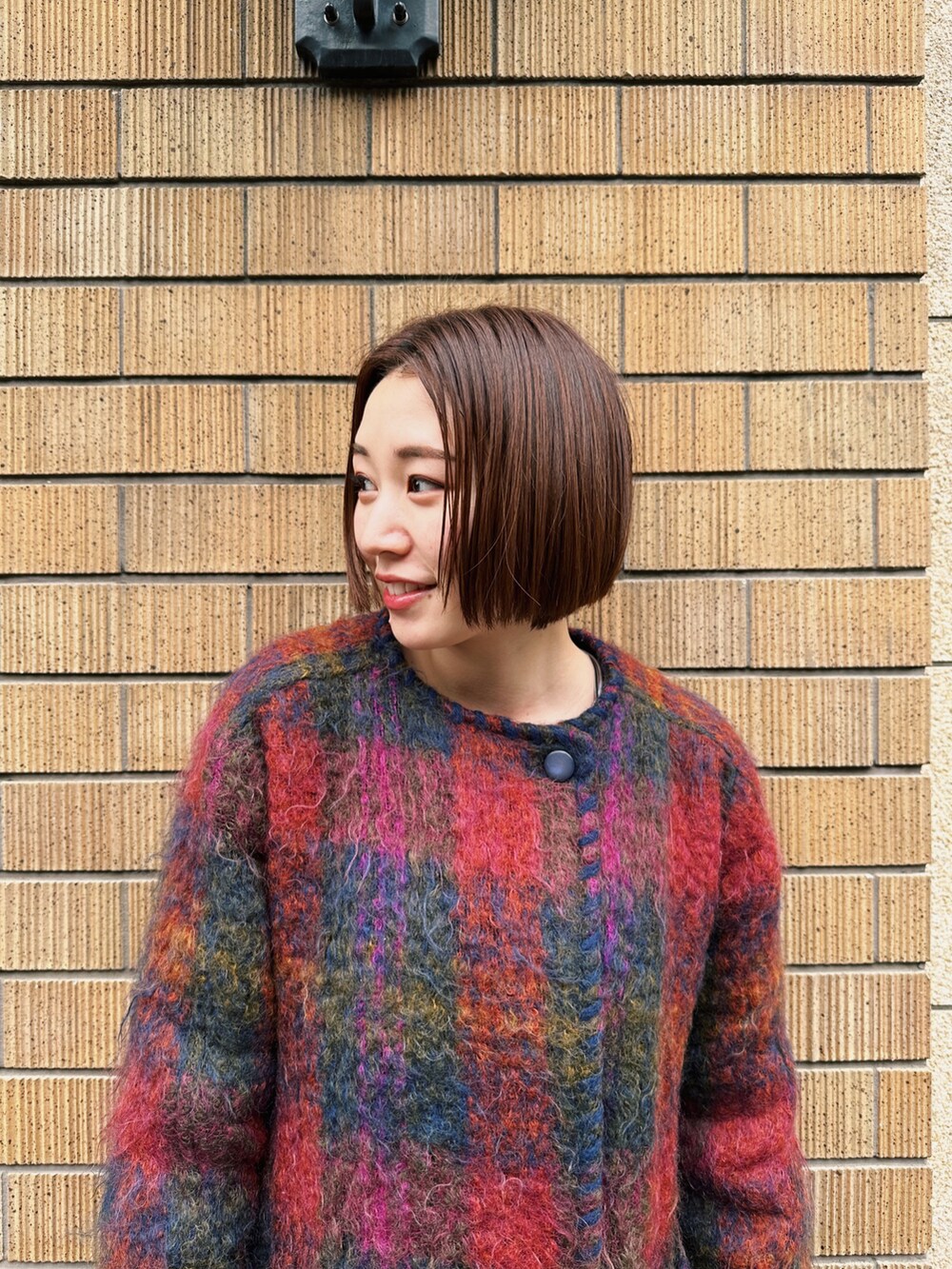 ブラック系のブーツ、ブルー系のデニムパンツ、レッド系のジャケット/アウターを着用したレディースの冬コーディネートの2枚目の写真