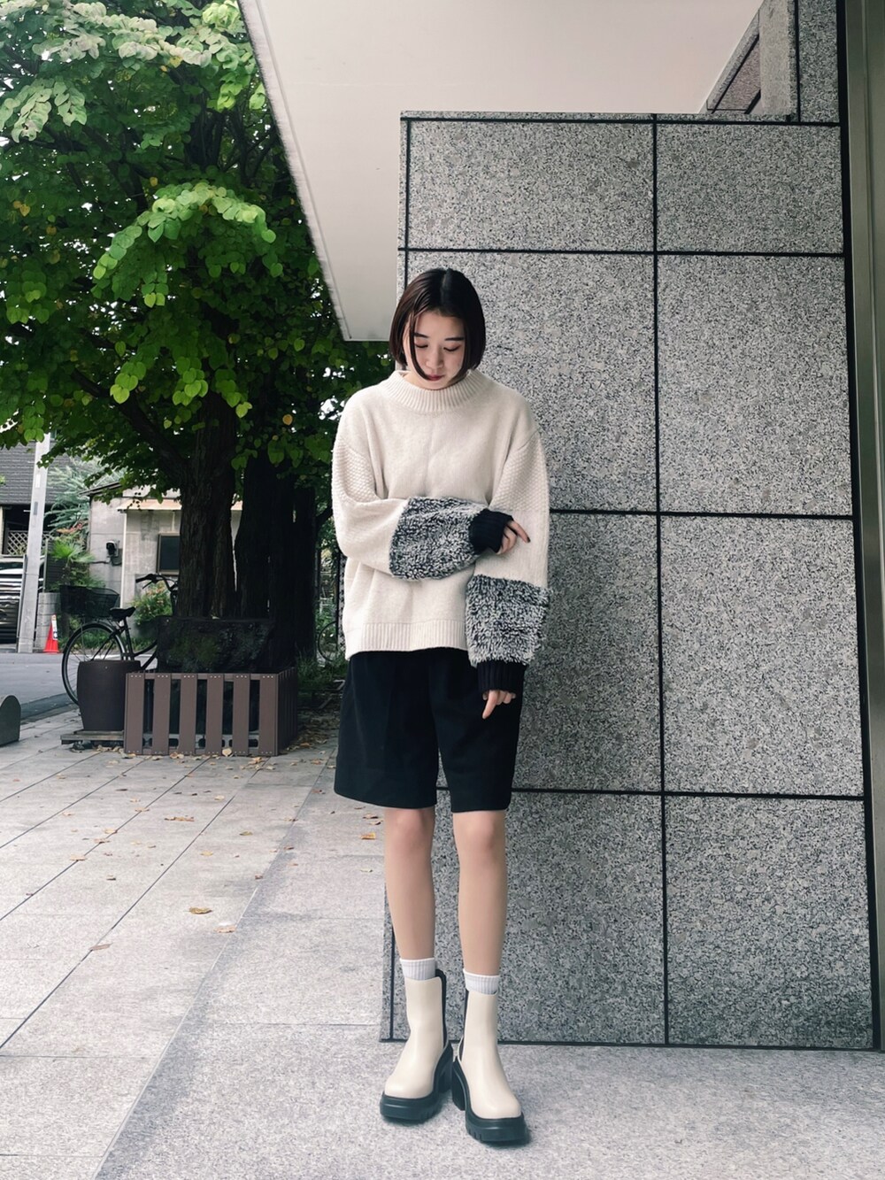 ブラック系のその他パンツ、ベージュ系のニット/セーター、ホワイト系のブーツを着用したレディースの秋コーディネートの3枚目の写真