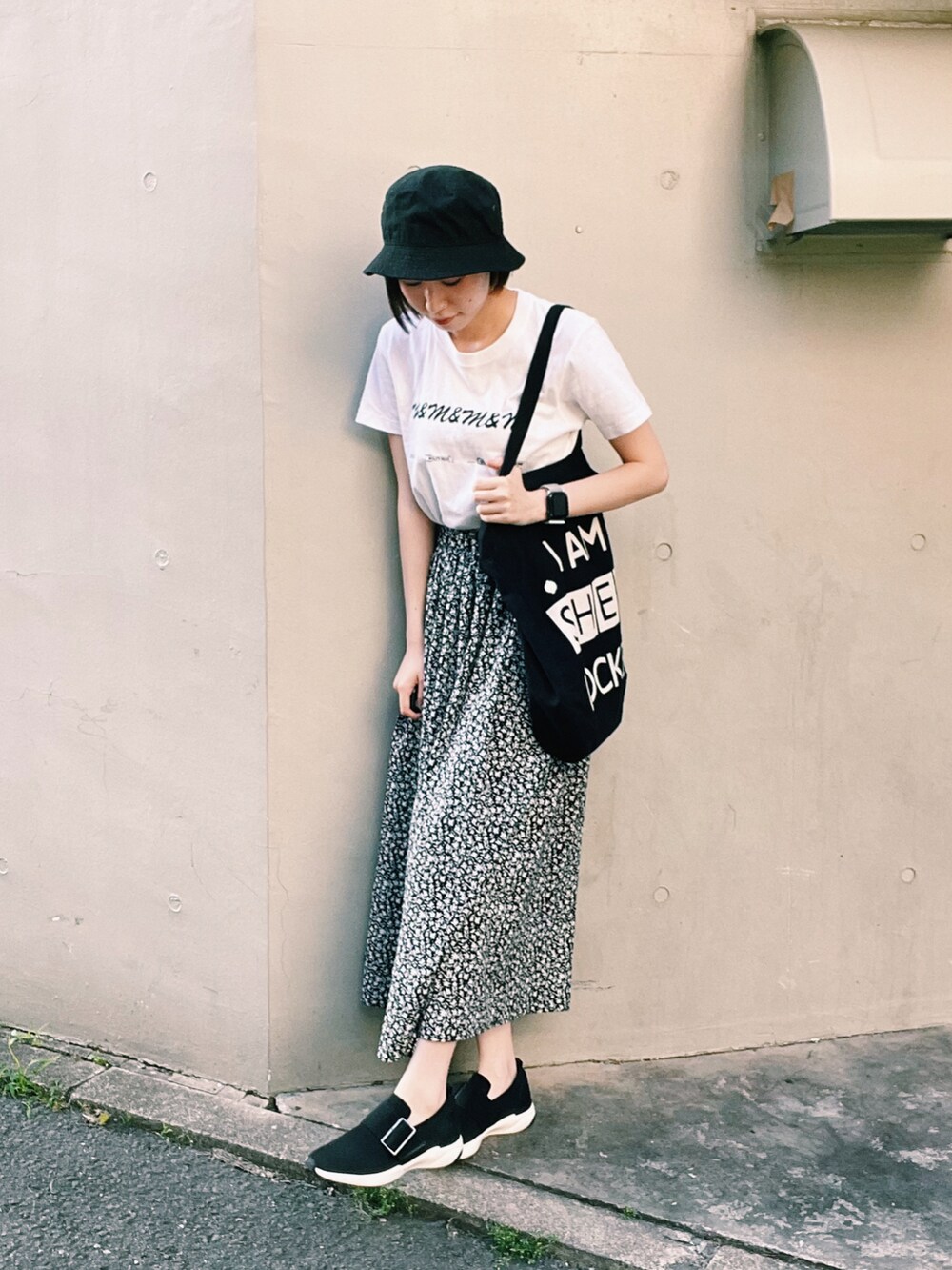 ホワイト系のTシャツ/カットソー、ブラック系のスニーカー、ブラック系のハットを着用したレディースの春コーディネートの2枚目の写真