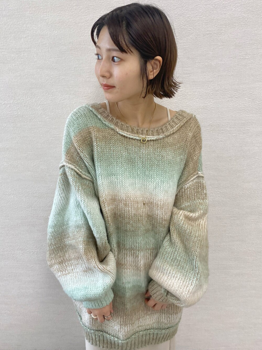 ブラック系のワンピース、ブルー系のショルダーバッグ、グリーン系のカーディガン/ボレロを着用したレディースの夏コーディネートの2枚目の写真