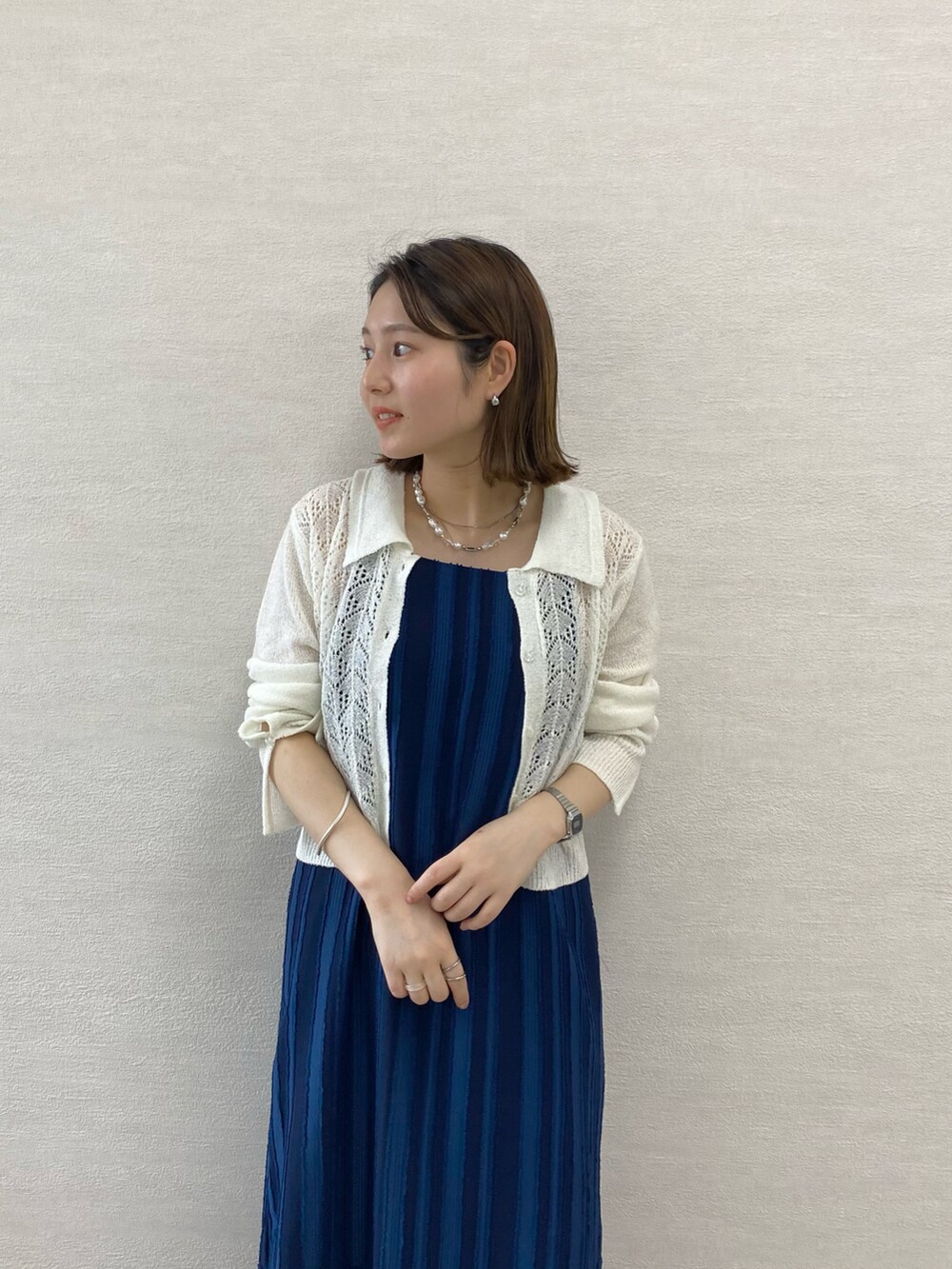 ブルー系のワンピース、ホワイト系のカーディガン/ボレロ、ホワイト系のサンダルを着用したレディースの春コーディネートの2枚目の写真