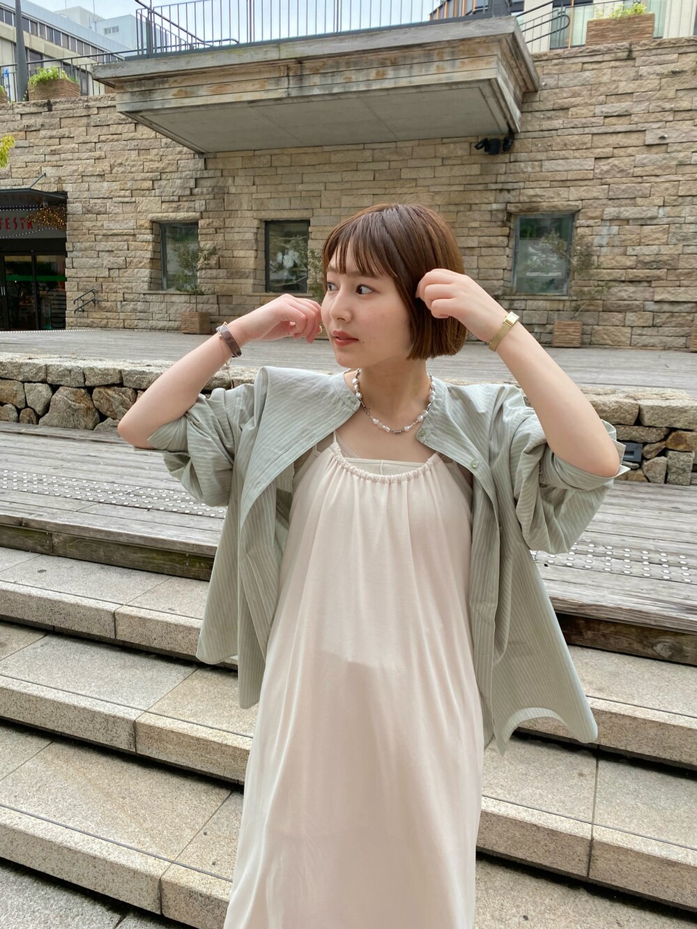 ホワイト系のワンピース、ホワイト系のその他パンツ、グリーン系のシャツ/ブラウスを着用したレディースの春コーディネートの2枚目の写真