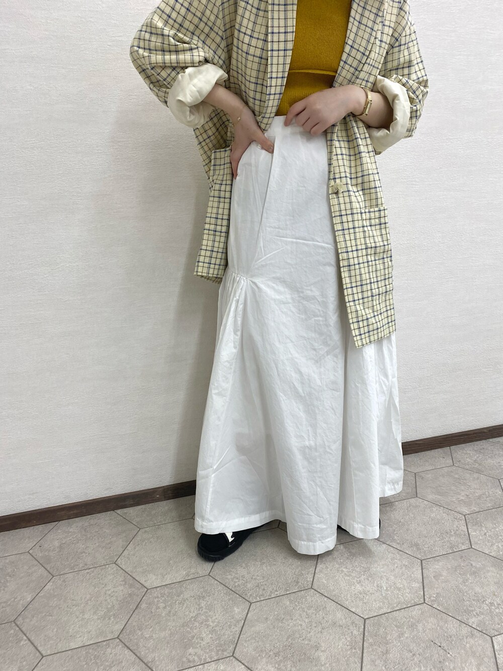 ホワイト系のスカート、イエロー系のキャミソール、ピンク系のショルダーバッグを着用したレディースの春コーディネートの3枚目の写真