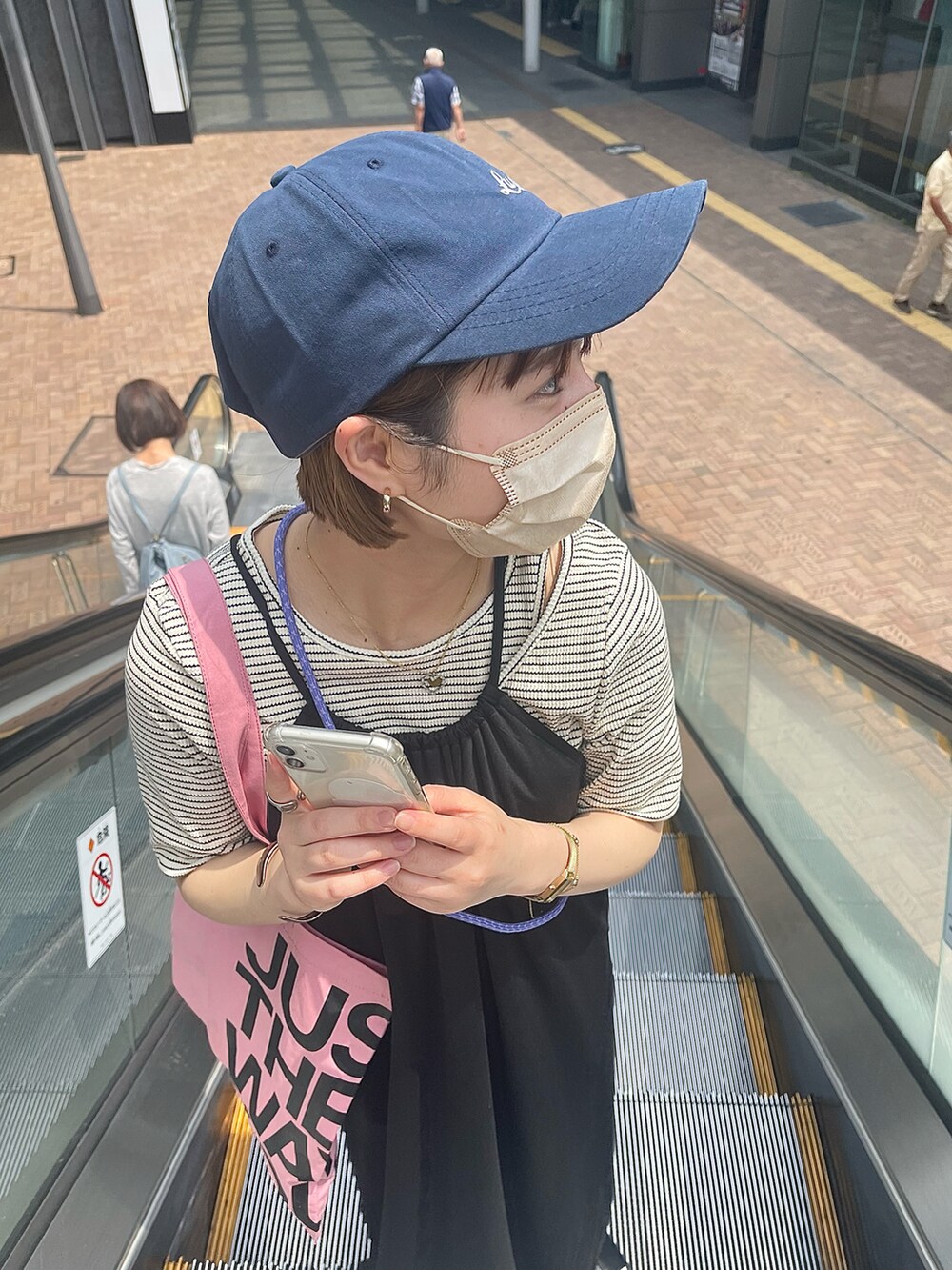 ブラック系のサンダル、ホワイト系のワンピース、ピンク系のトートバッグを着用したレディースの春コーディネートの2枚目の写真