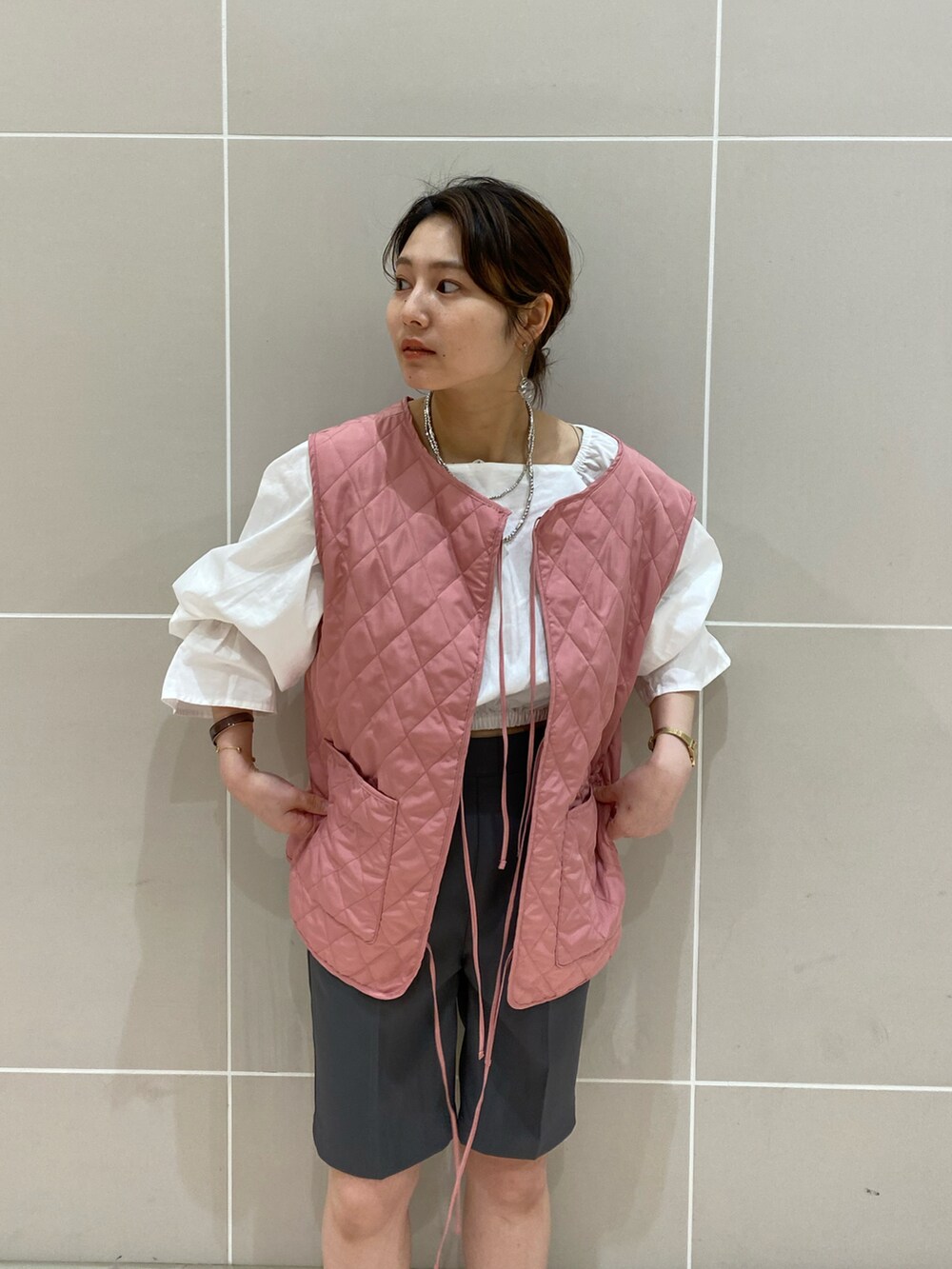 ブラック系のローファー、ホワイト系のシャツ/ブラウス、ピンク系のベストを着用したレディースの春コーディネートの2枚目の写真