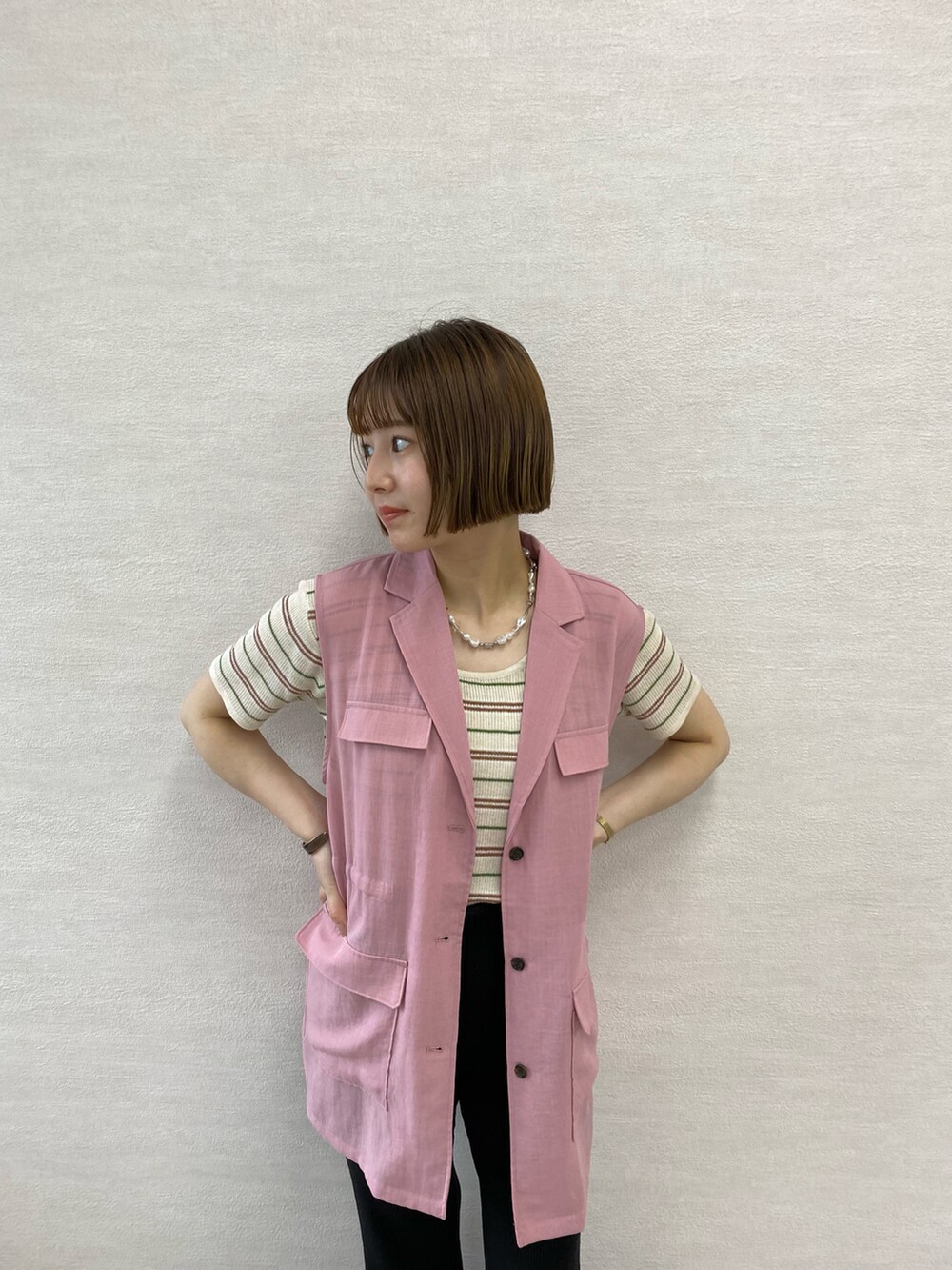 ホワイト系のその他パンツ、ブラック系のサンダル、グリーン系のベストを着用したレディースの春コーディネートの2枚目の写真