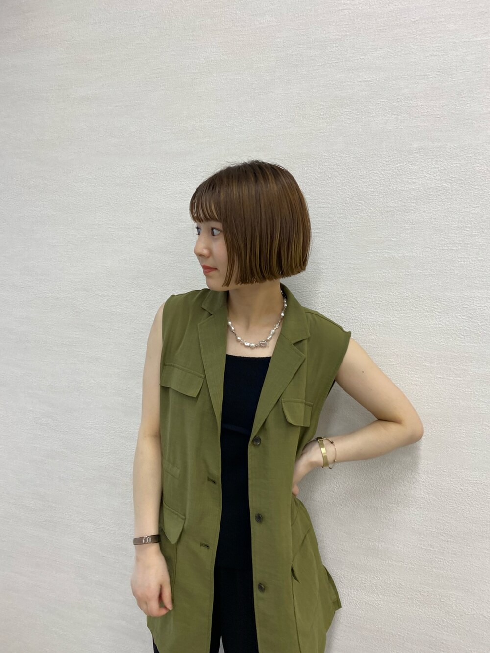 グリーン系のベスト、ブラック系のその他パンツ、ブラック系のサンダルを着用したレディースの春コーディネートの2枚目の写真