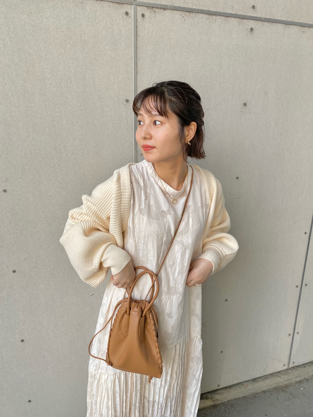 ブラック系のローファー、ホワイト系のワンピース、ブルー系のショルダーバッグを着用したレディースの夏コーディネートの2枚目の写真