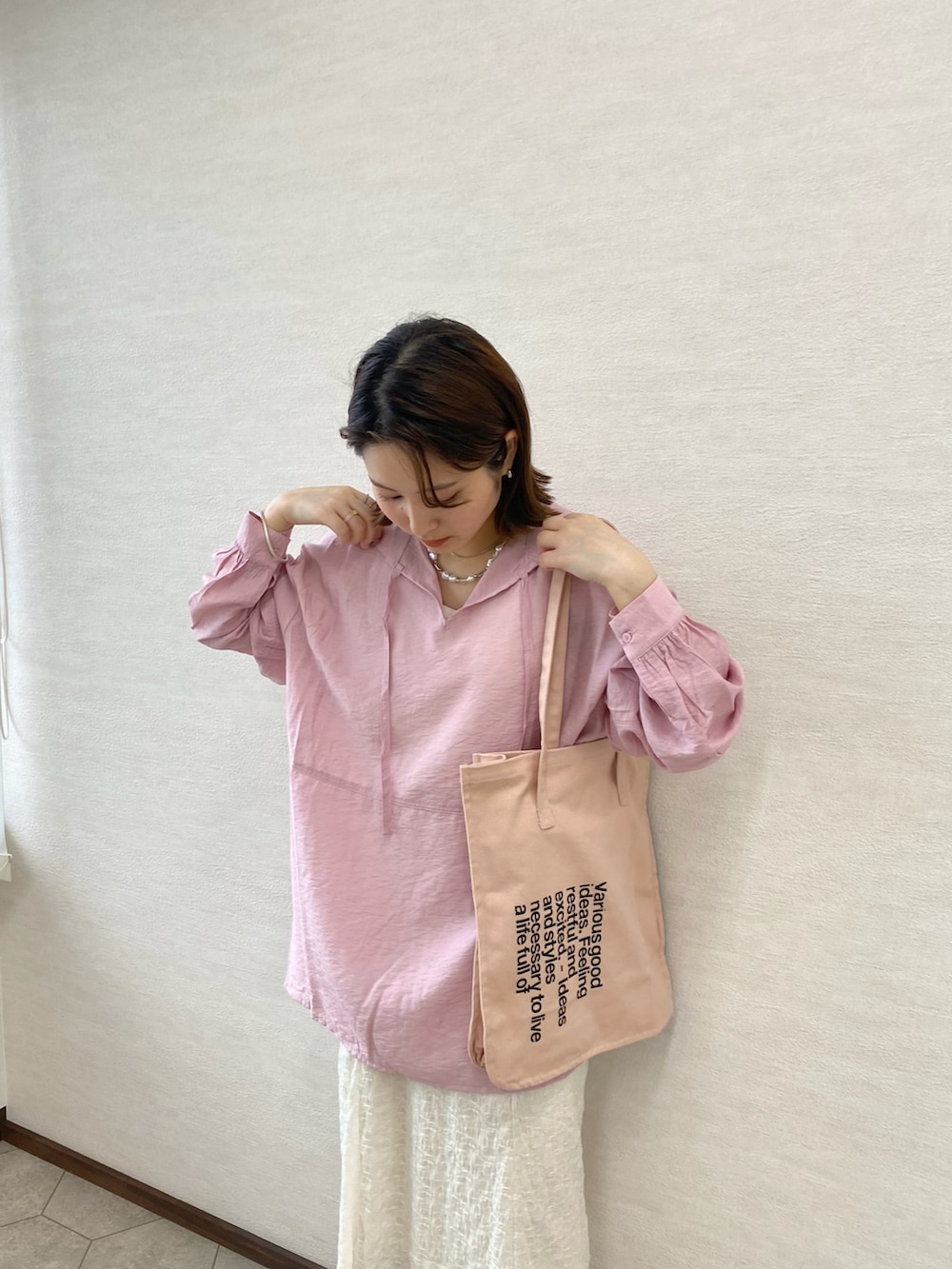 ホワイト系のサンダル、ピンク系のトートバッグ、ピンク系のシャツ/ブラウスを着用したレディースの春コーディネートの2枚目の写真