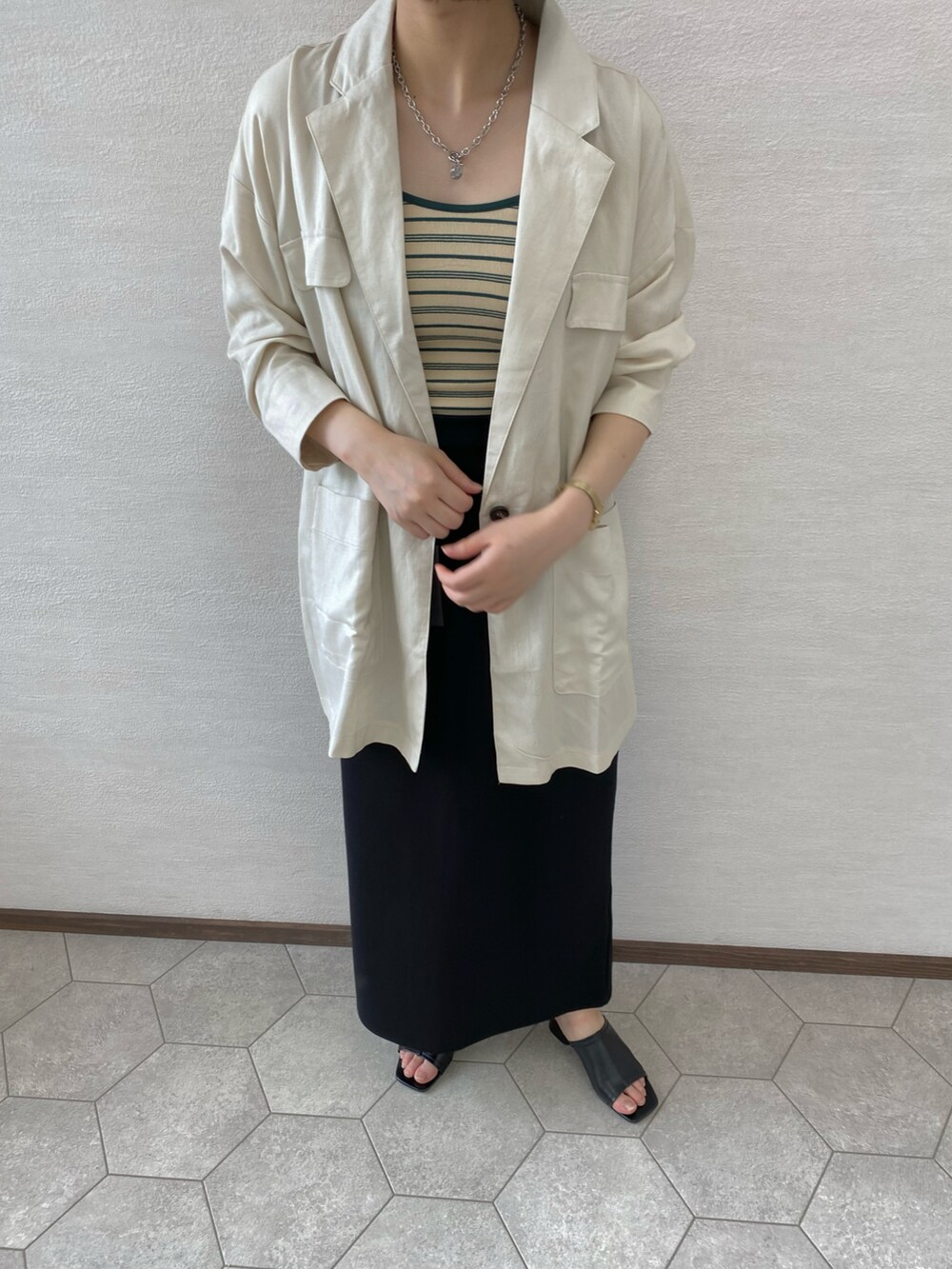 ホワイト系のキャミソール、グリーン系のスカート、ピンク系のテーラードジャケットを着用したレディースの夏コーディネートの2枚目の写真