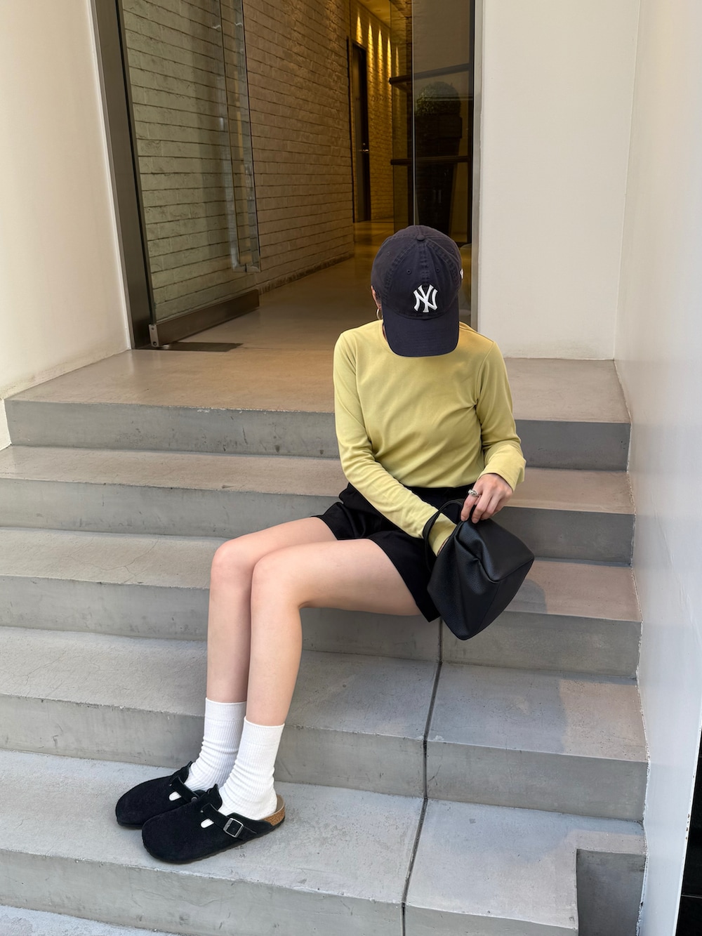 イエロー系のTシャツ/カットソー、ブラック系のその他パンツを着用したレディースの秋コーディネートの3枚目の写真