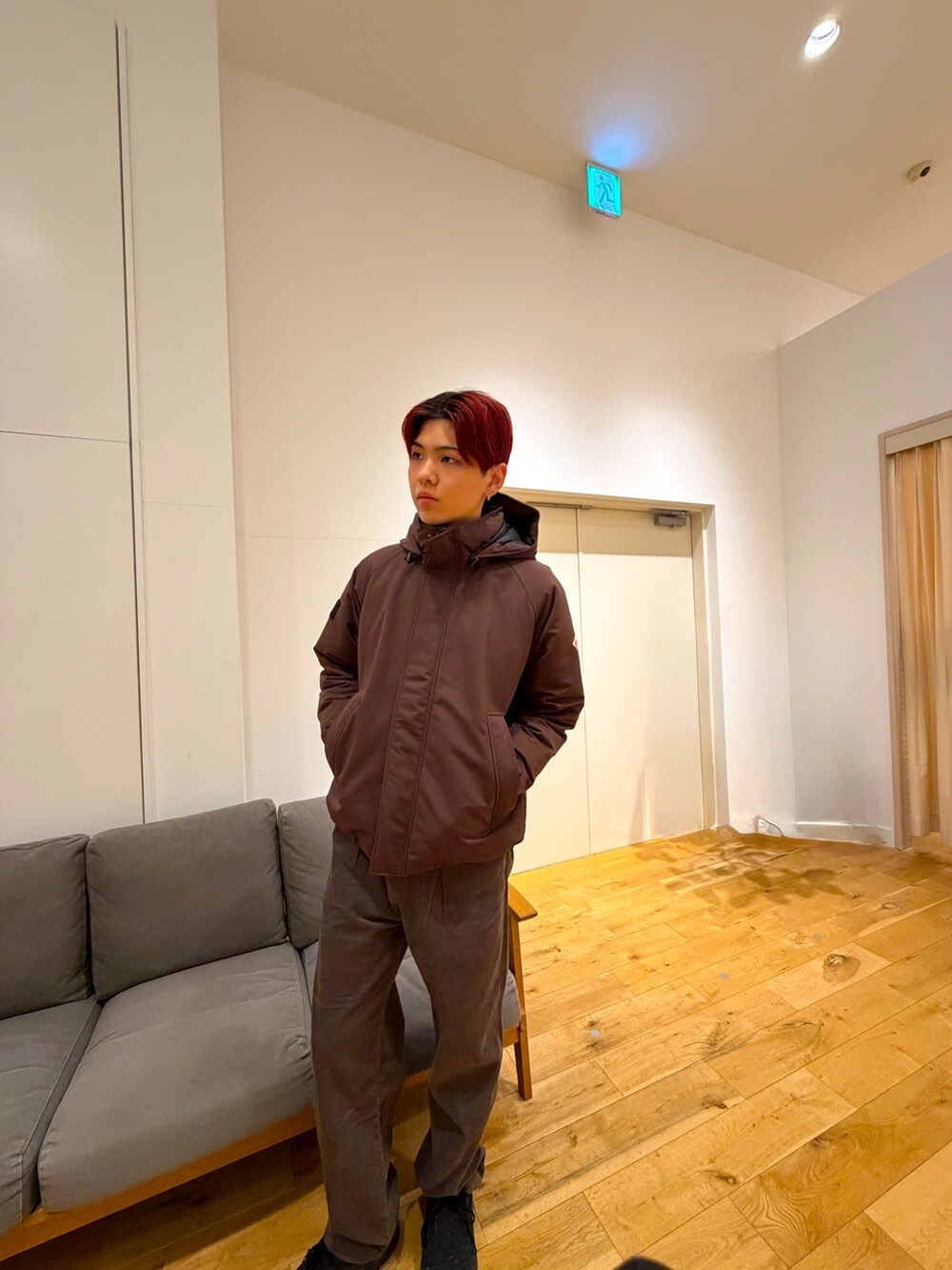 ブラウン系のジャケット/アウター、レッド系のニット/セーター、ブラウン系のその他パンツを着用したメンズの冬コーディネートの2枚目の写真