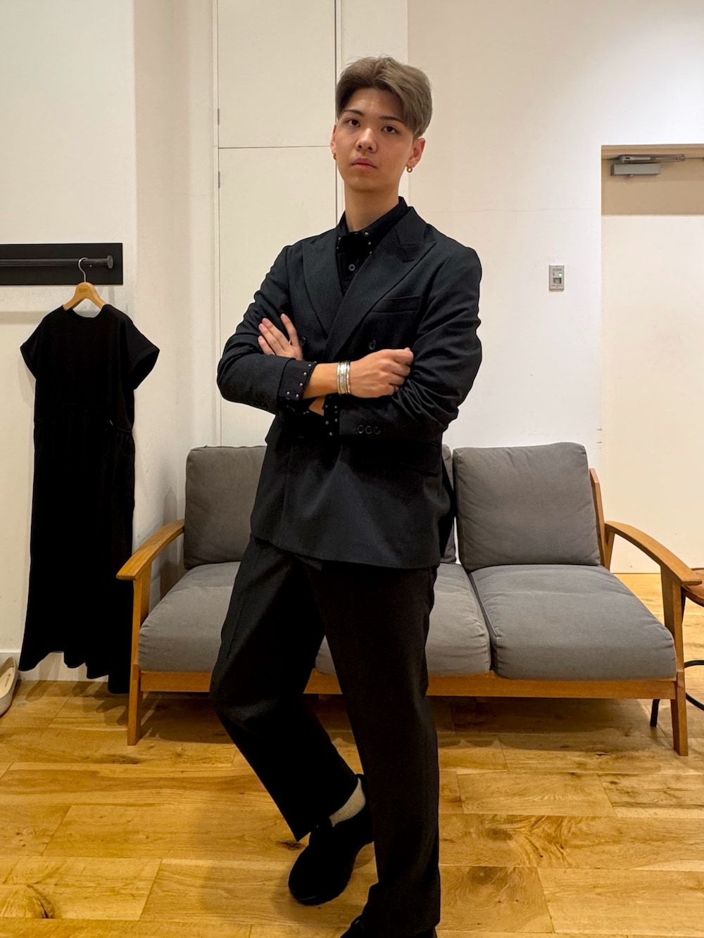 ブラック系のスーツジャケット、ブラック系のスニーカー、ブラック系のスーツパンツを着用したメンズの秋コーディネートの3枚目の写真