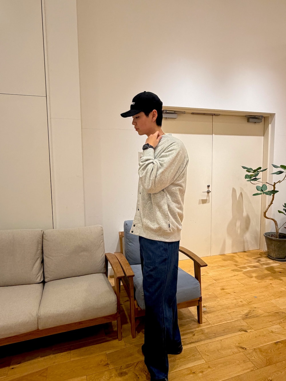 グレー系のカーディガン/ボレロ、ブルー系のデニムパンツ、ブラック系のスニーカーを着用したメンズの冬コーディネートの2枚目の写真