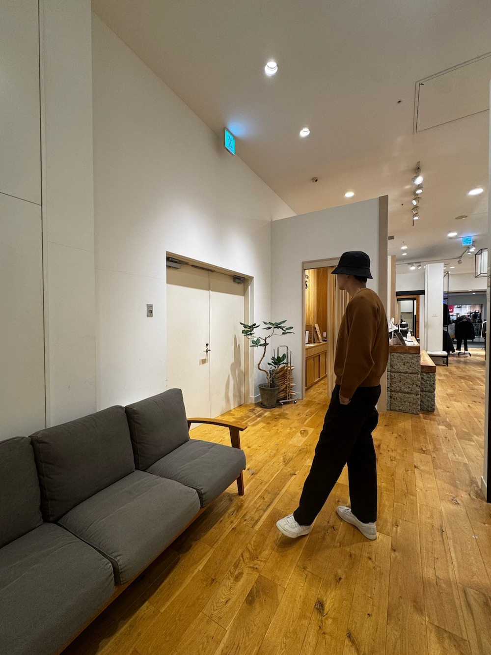 ブラウン系のニット/セーター、ブラック系のその他パンツ、ホワイト系のスニーカーを着用したメンズの秋コーディネートの3枚目の写真