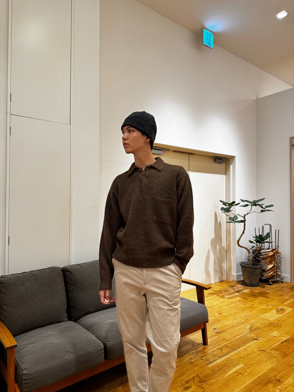 ブラウン系のニット/セーター、ホワイト系のその他パンツ、ブラック系のブーツを着用したメンズの秋コーディネートの6枚目の写真