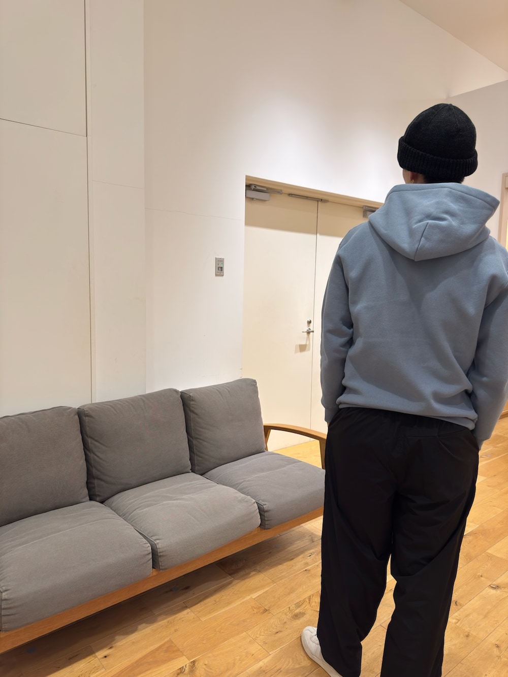 ブルー系のパーカー、ブラック系のその他パンツ、ホワイト系のスニーカーを着用したメンズの秋コーディネートの2枚目の写真