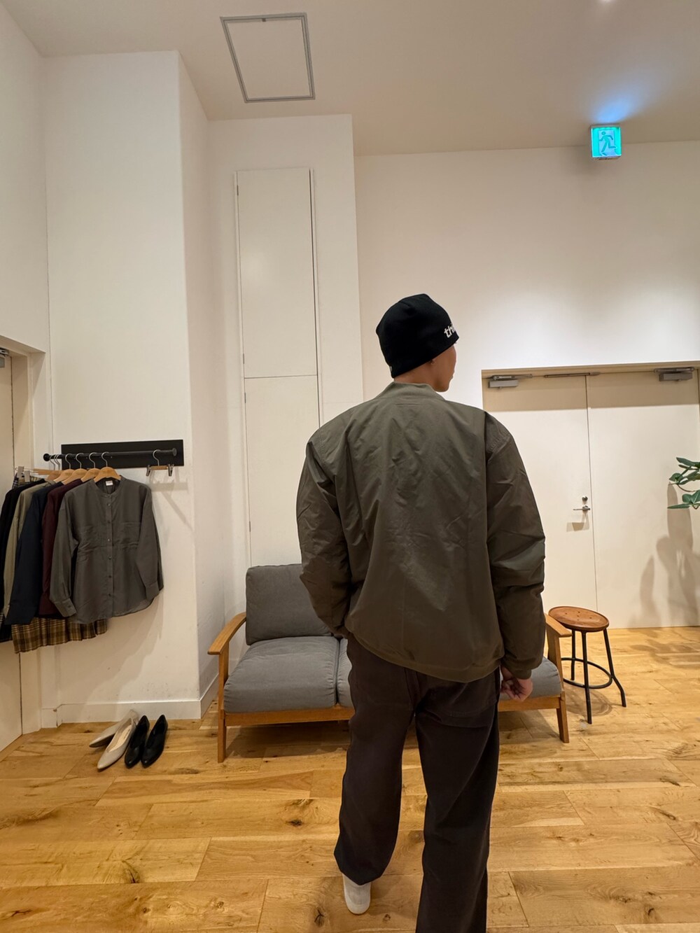 グリーン系のジャケット/アウター、ブラック系のパンツ、ホワイト系のスニーカーを着用したメンズの秋コーディネートの9枚目の写真