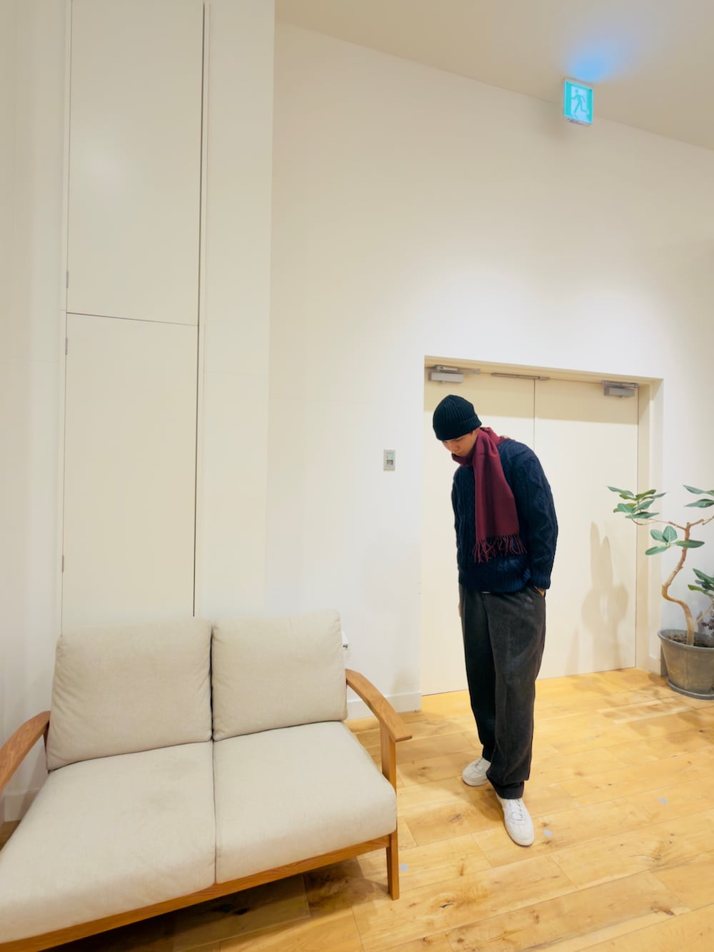 ブルー系のニット/セーター、グレー系のその他パンツ、ホワイト系のスニーカーを着用したメンズの冬コーディネートの2枚目の写真