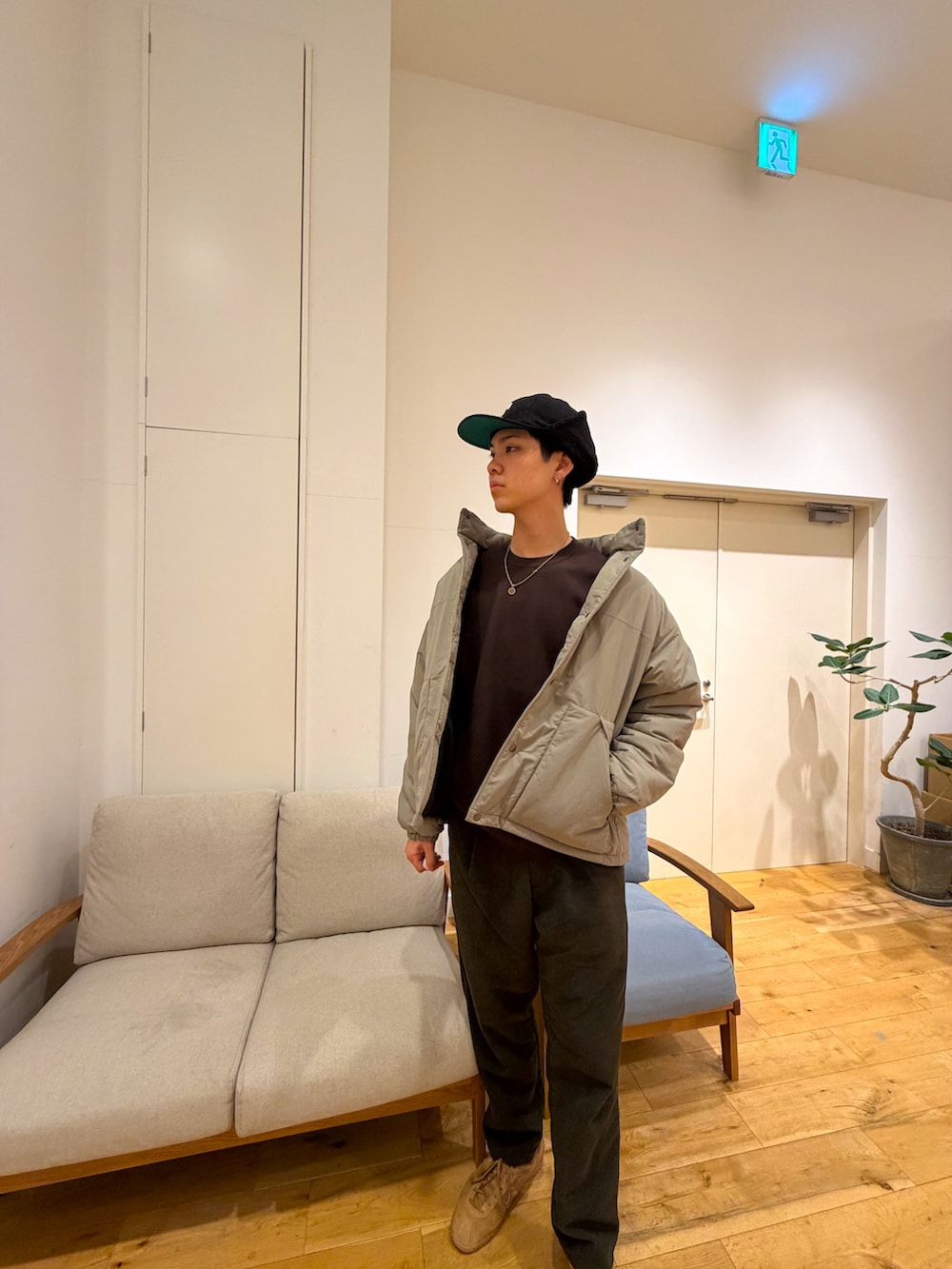 ベージュ系のダウンジャケット/コート、ブラウン系のニット/セーター、グリーン系のその他パンツを着用したメンズの冬コーディネートの3枚目の写真