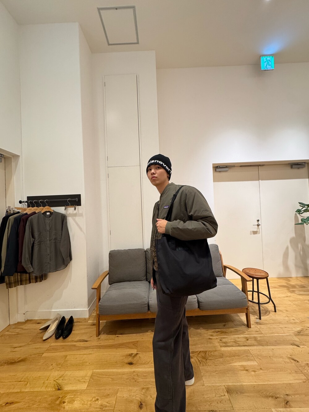 グリーン系のジャケット/アウター、ブラック系のパンツ、ホワイト系のスニーカーを着用したメンズの秋コーディネートの2枚目の写真