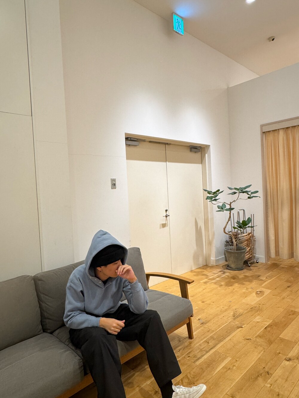 ブルー系のパーカー、ブラック系のその他パンツ、ホワイト系のスニーカーを着用したメンズの秋コーディネートの5枚目の写真