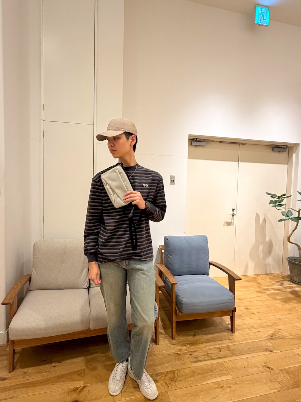 ブラック系のTシャツ/カットソー、ブラック系のデニムパンツ、ホワイト系のスニーカーを着用したメンズの冬コーディネートの3枚目の写真