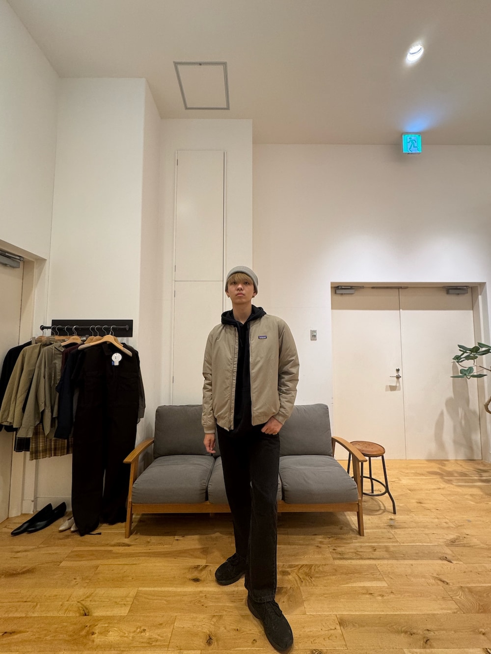 ベージュ系のジャケット/アウター、ブラック系のパーカー、ブラック系のデニムパンツを着用したメンズの秋コーディネートの5枚目の写真